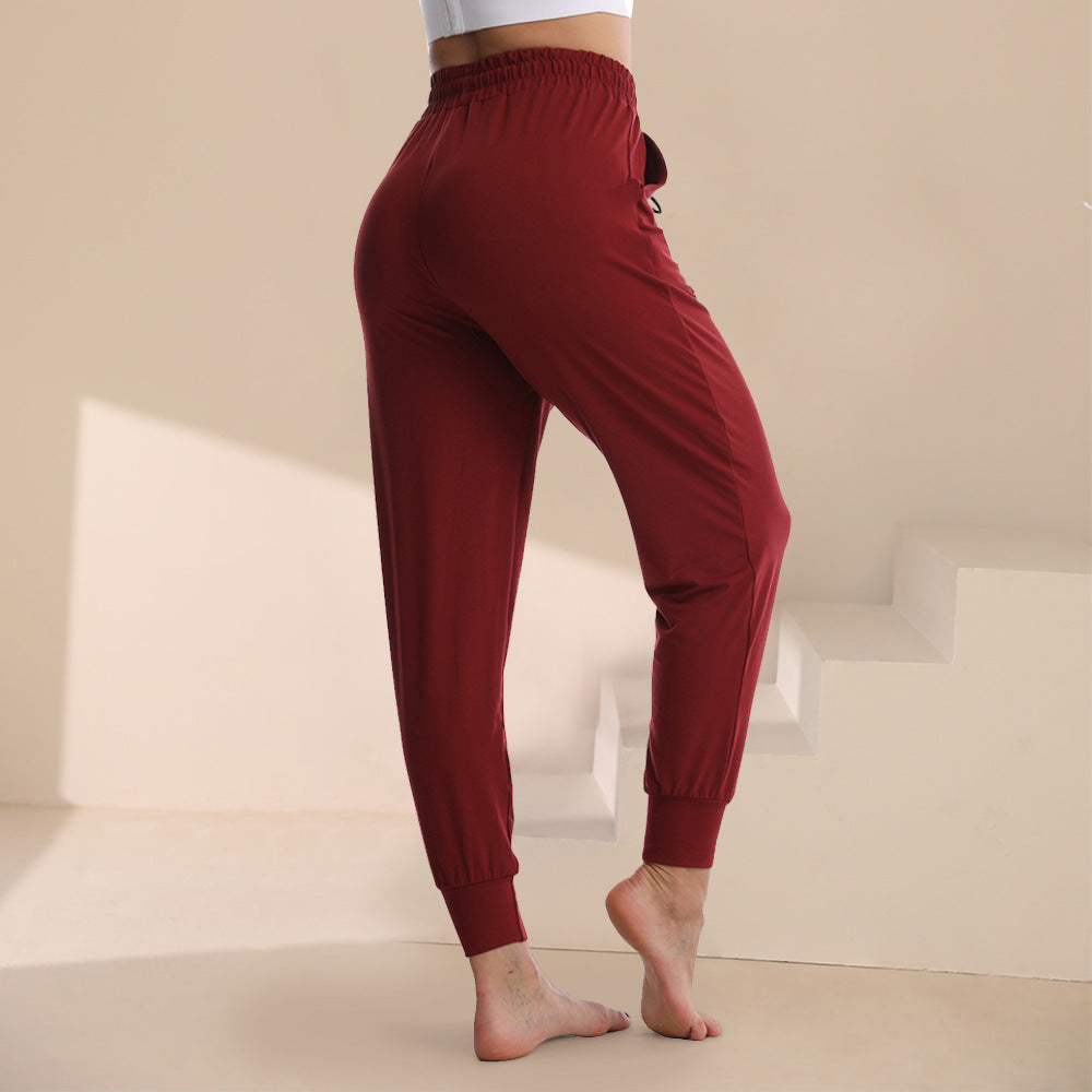 Wine red jogger pants with elastic waistband, drawstring, and tapered ankle cuffs