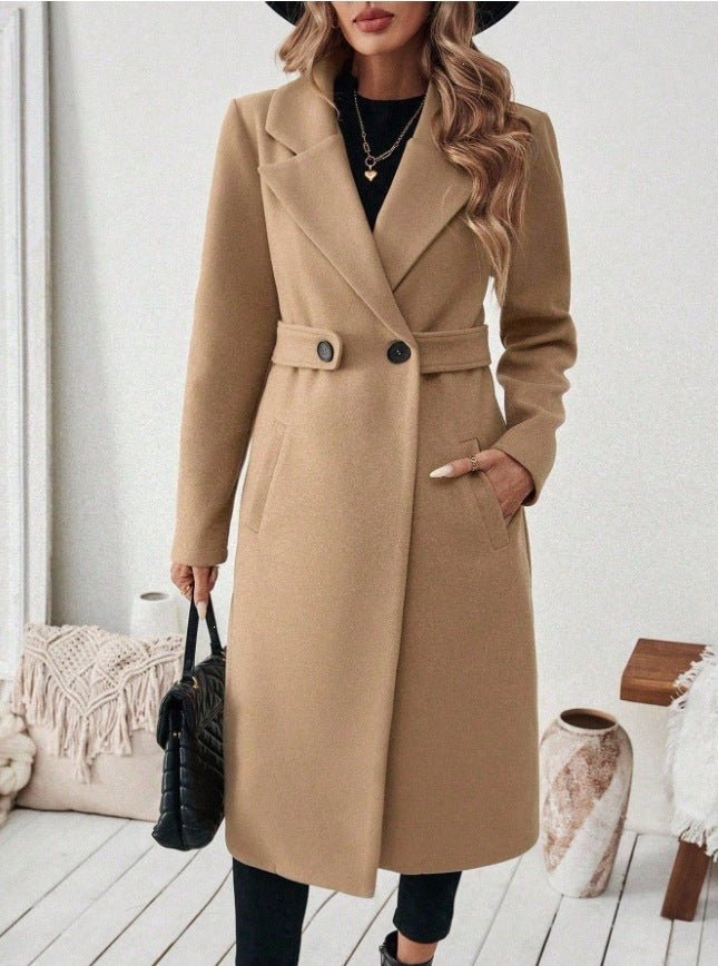 Beige wool long double-breasted coat with notched lapels, waist belt, and flap pockets.