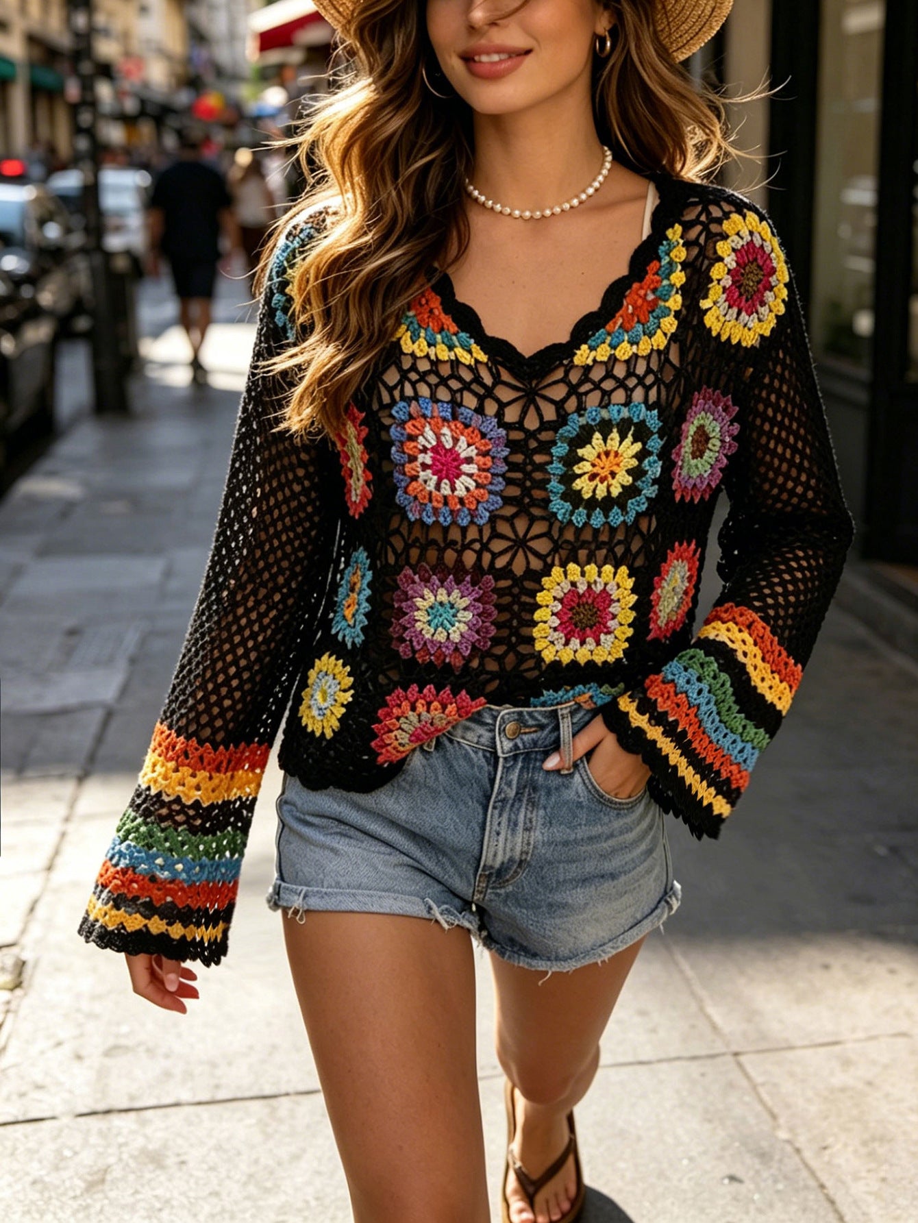 Granny square crochet top, black base with colorful floral motifs and long bell sleeves