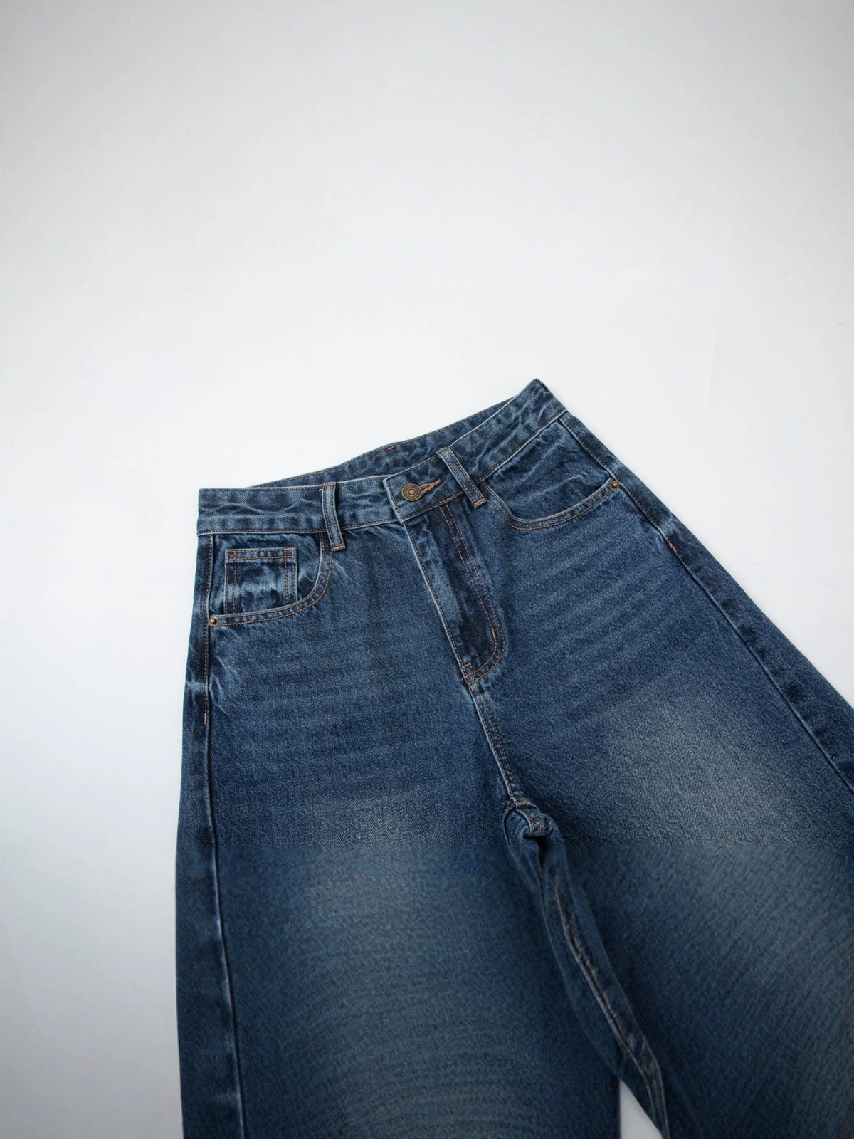 Women's dark blue denim jeans close-up, front waistband with belt loops and stitched pockets