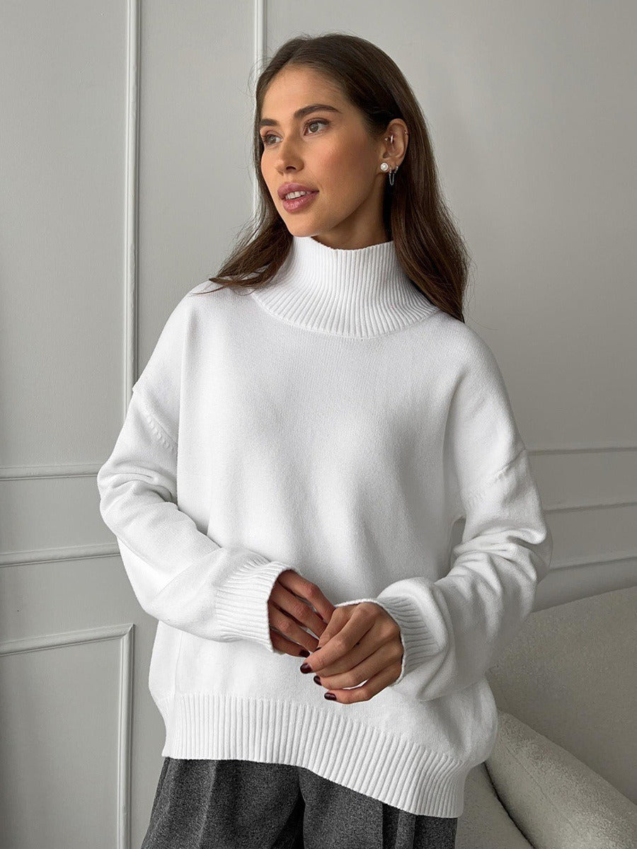 Loose turtleneck knit sweater in white, ribbed hem and collar, relaxed fit.