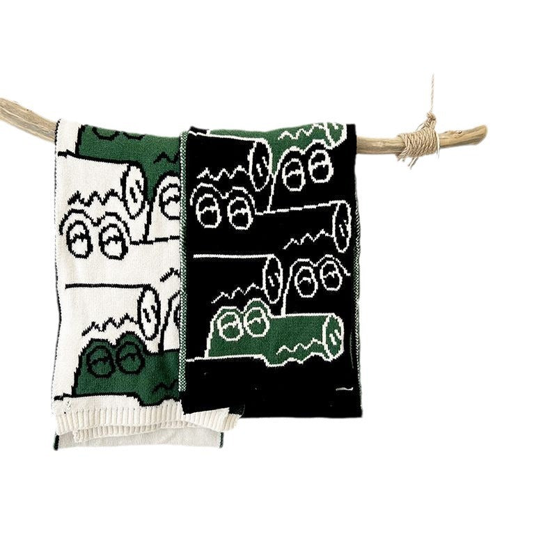 Knitted scarf with green and white pattern panels and short tassel ties