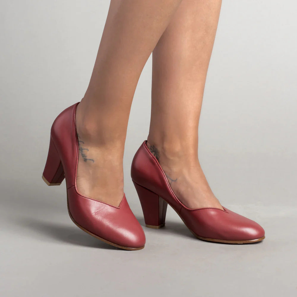 Red women's pumps with a shallow V-cut topline and block heels