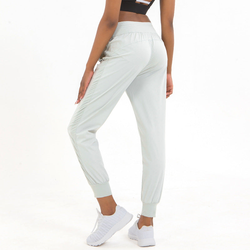White jogger pants with elastic waistband drawstring and tapered ankle cuffs