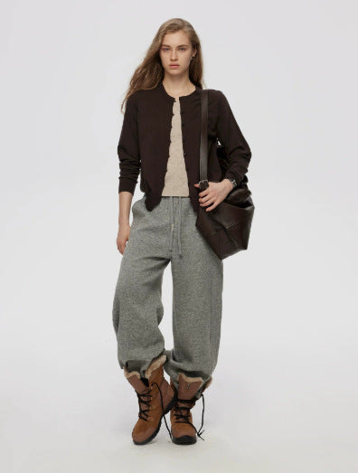 Brown women's knitted cardigan worn with gray drawstring pants