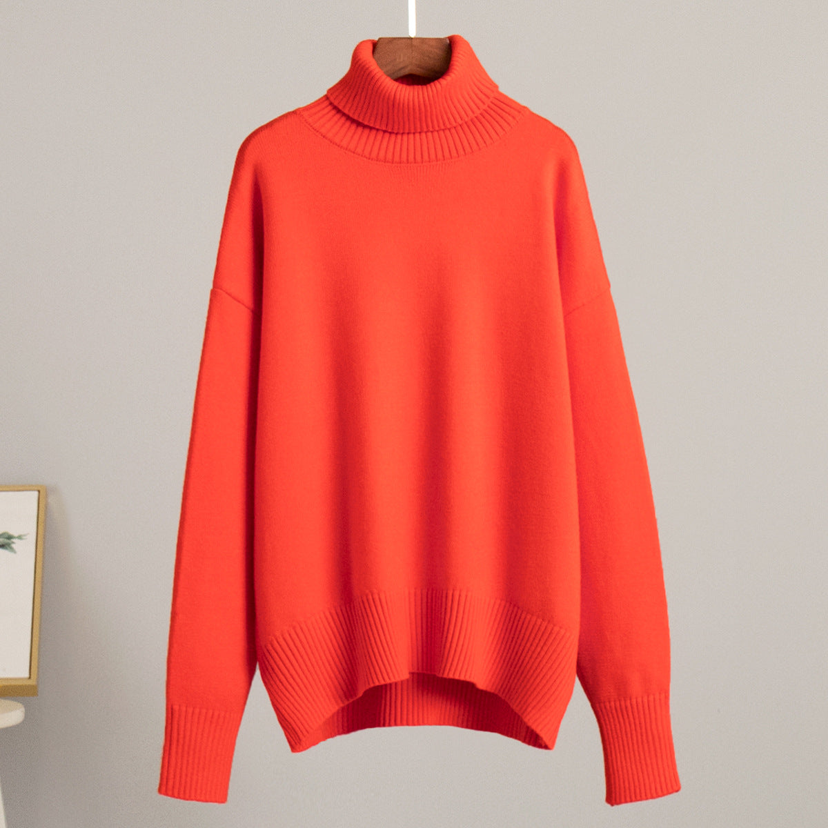 Orange-red knit turtleneck pullover sweater with loose fit and ribbed cuffs