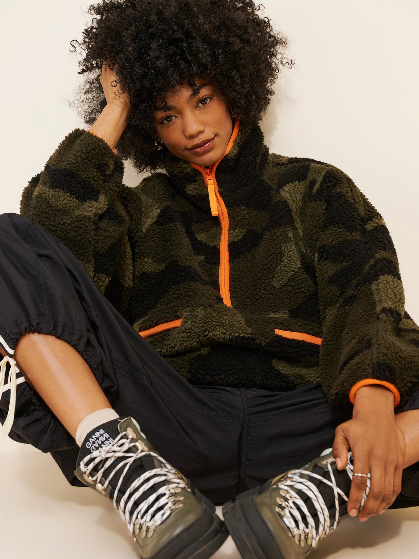 Olive camo teddy fleece jacket with orange zipper and contrast trim at cuffs