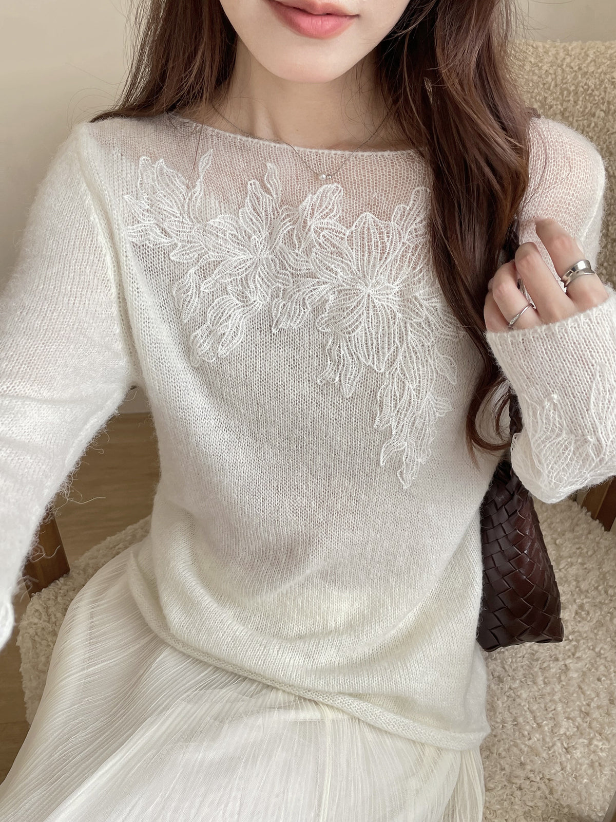 Off-white long-sleeve knit top with floral chest embroidery and ribbed cuffs