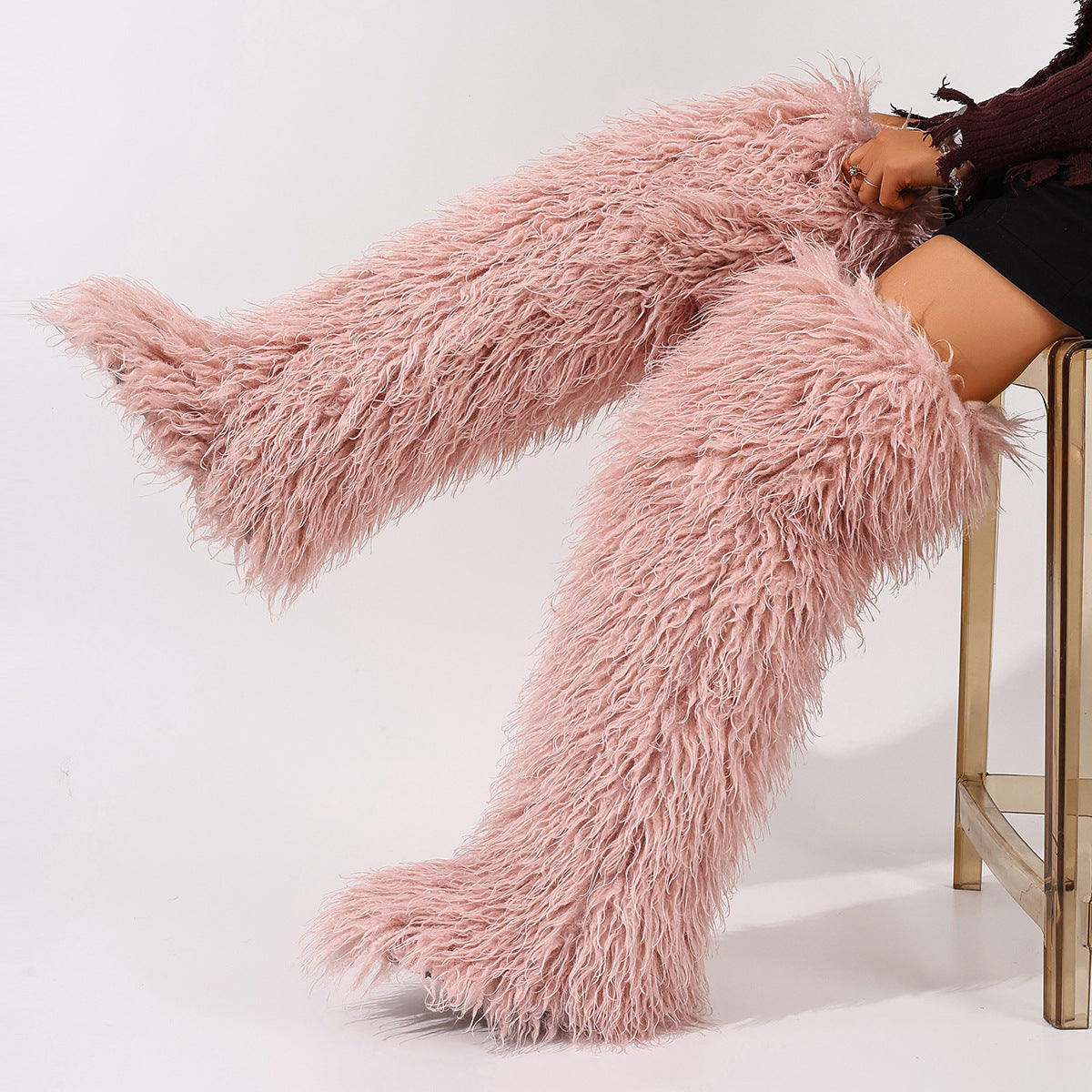 Pale pink shaggy faux fur thigh-high boots shown at an angle