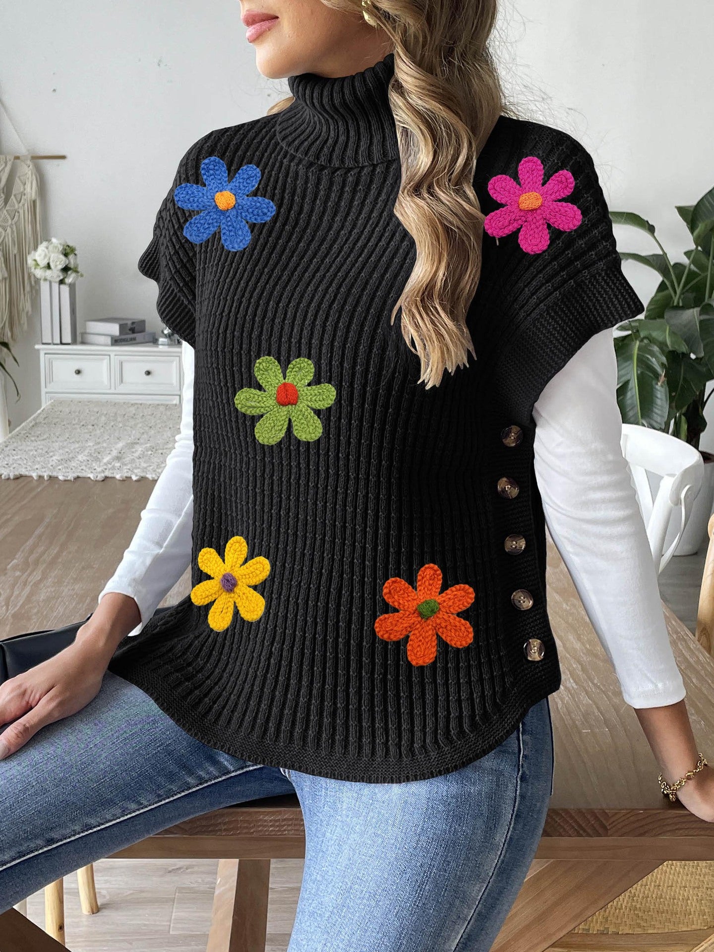 Black knit high-neck sweater vest with flower appliques and button placket detail
