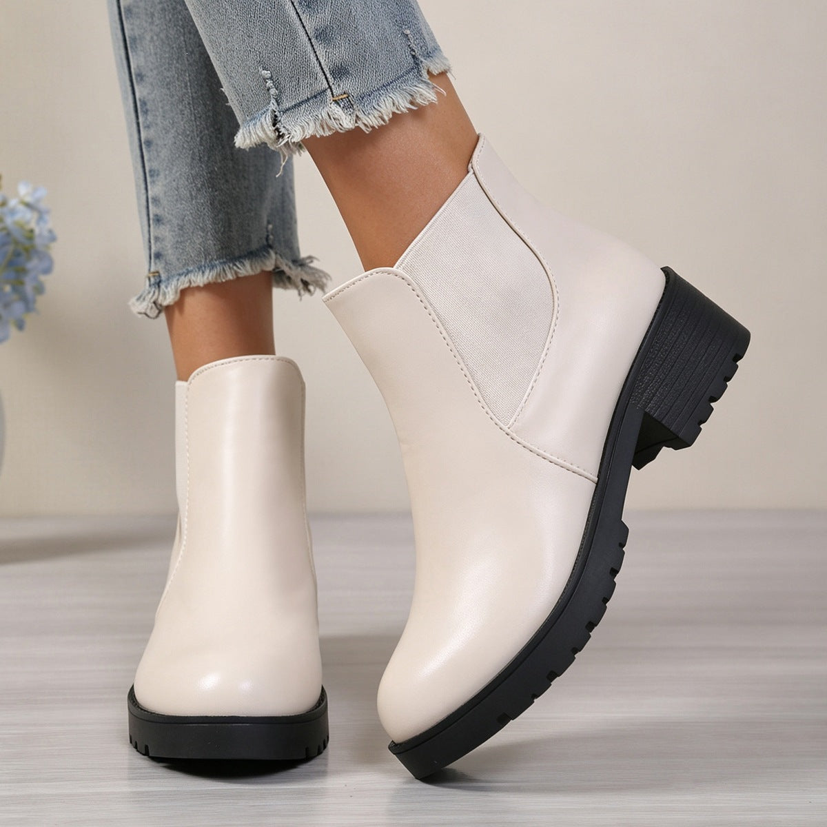White pull-on Chelsea boots with rounded toe, elastic side panels, and thick block heel