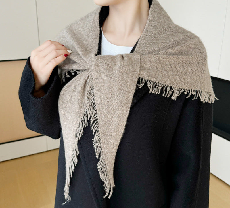 Beige cashmere triangle scarf with fringe tassels, draped around shoulders