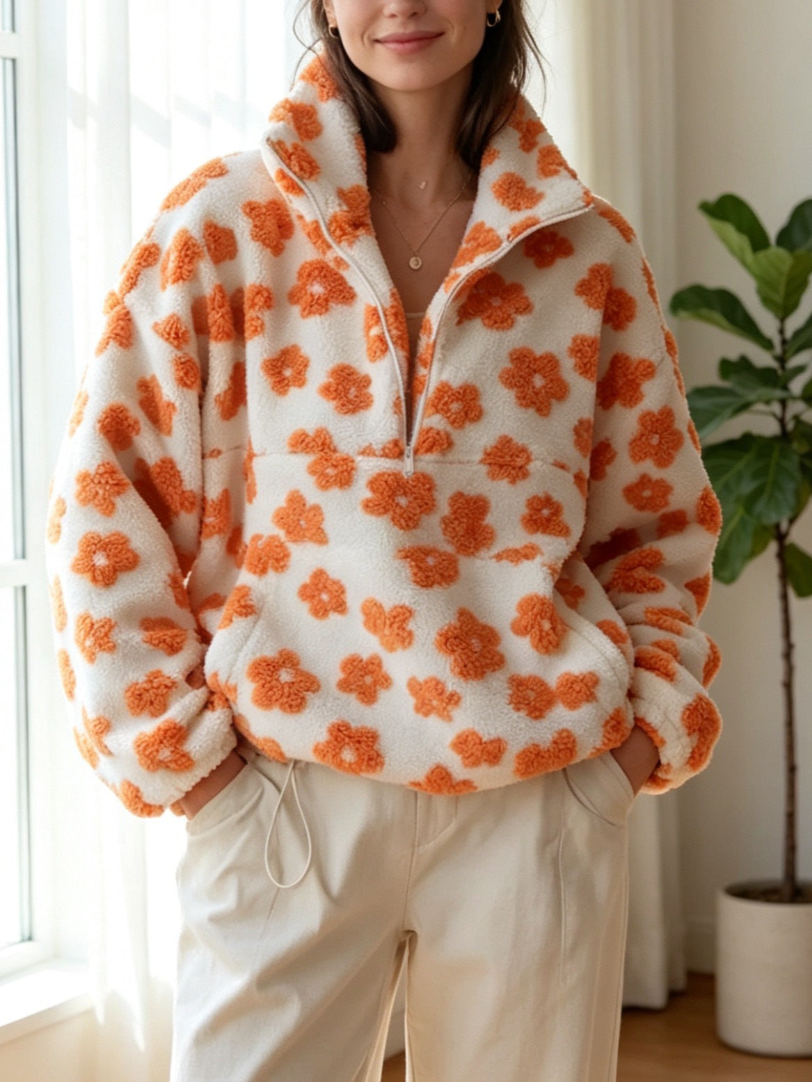 White fleece half-zip hoodie with orange floral pattern and long sleeves