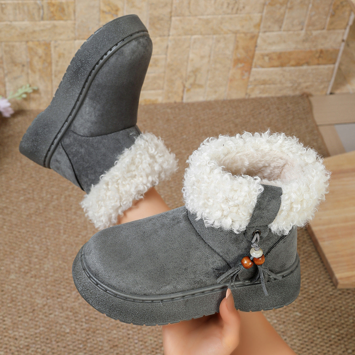 Gray suede ankle boots with white faux-fur cuffs and tassel charm detail