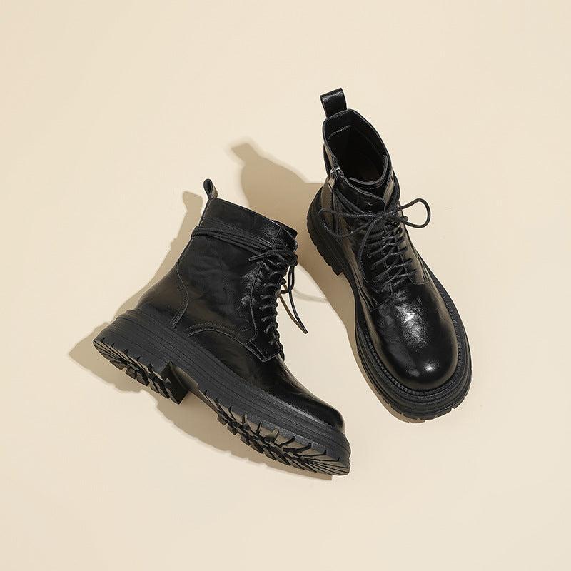 Black lace-up ankle combat boots with shiny finish and chunky lug sole