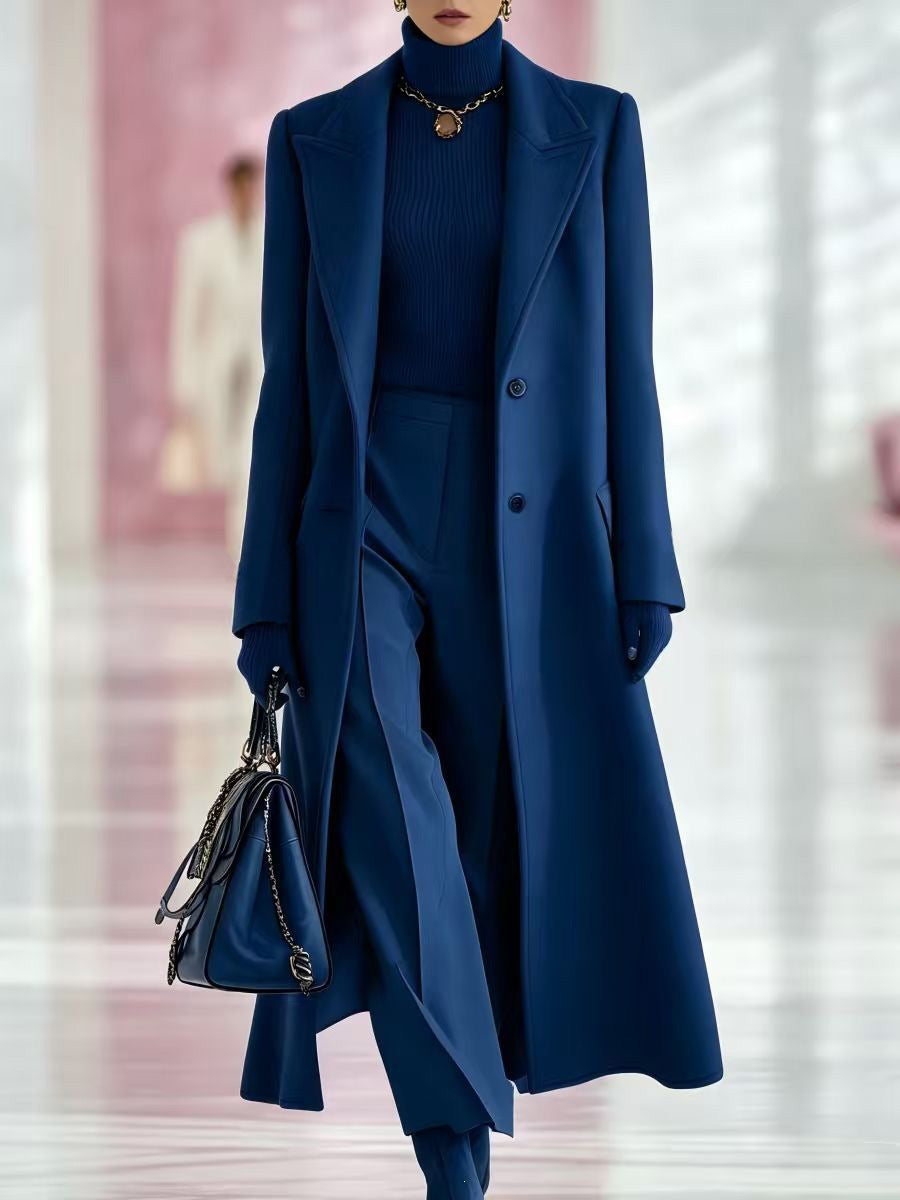 Royal blue long tailored coat with peak lapels, two buttons, and a slim silhouette