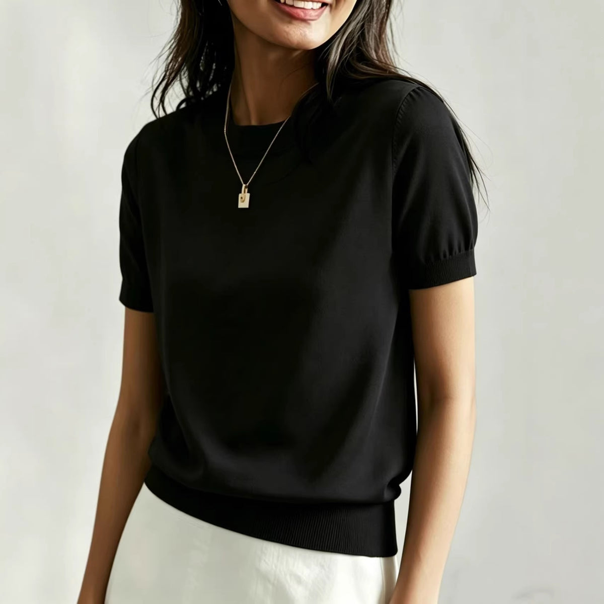 Women's black round-neck t-shirt with short puff sleeves and ribbed hem