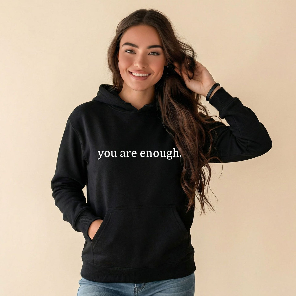 Black women’s hoodie sweatshirt with hood, front pocket, and 'you are enough' print.