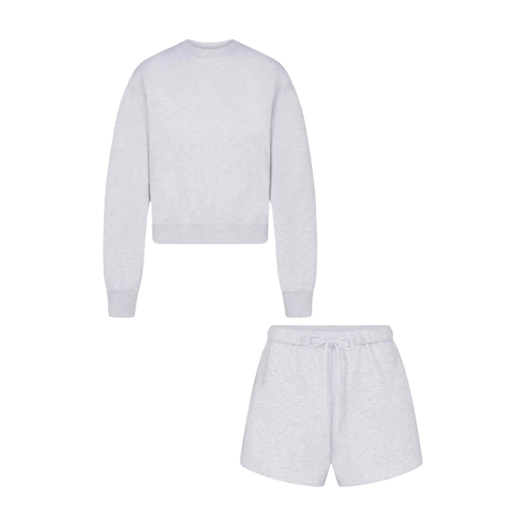 Women’s light gray two-piece set: cropped sweatshirt and matching shorts with drawstring.