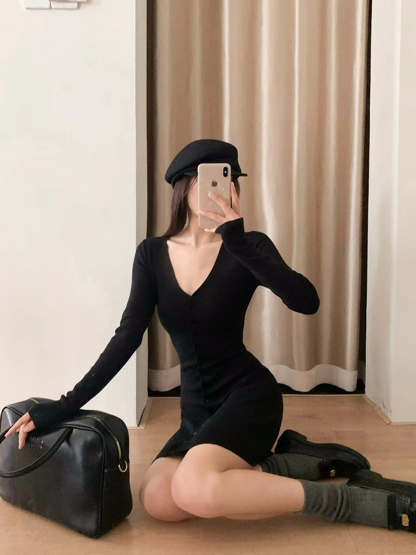 Black knit mini dress with V-neck and button front, long sleeves, short A-line hem.
