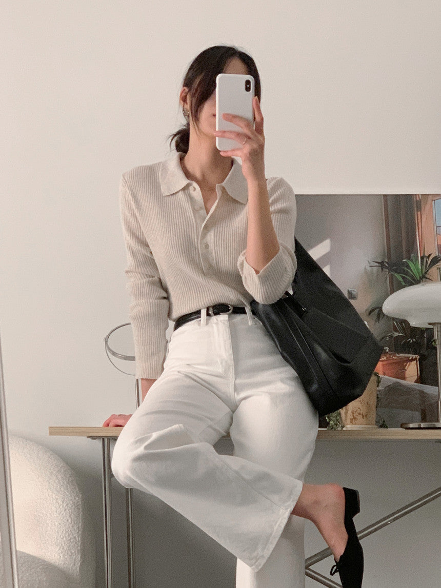 White knit polo collar long-sleeve top with button placket and ribbed knit body.
