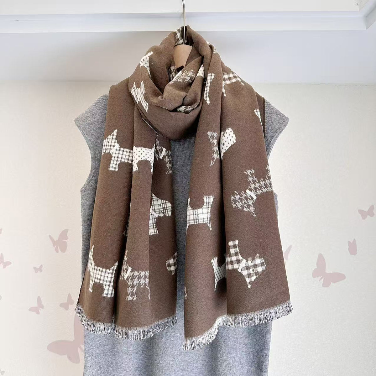 Brown scarf with dog motifs and fringed ends, draped around the neck