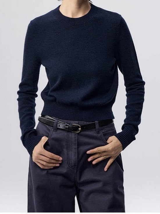 Navy crewneck knit sweater with long sleeves and ribbed hem, worn with jeans
