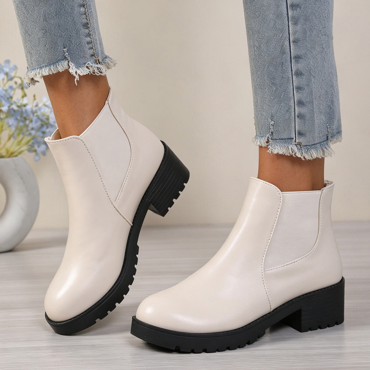 White Chelsea ankle boots with rounded toe, elastic side panels, and chunky rubber mid-heel