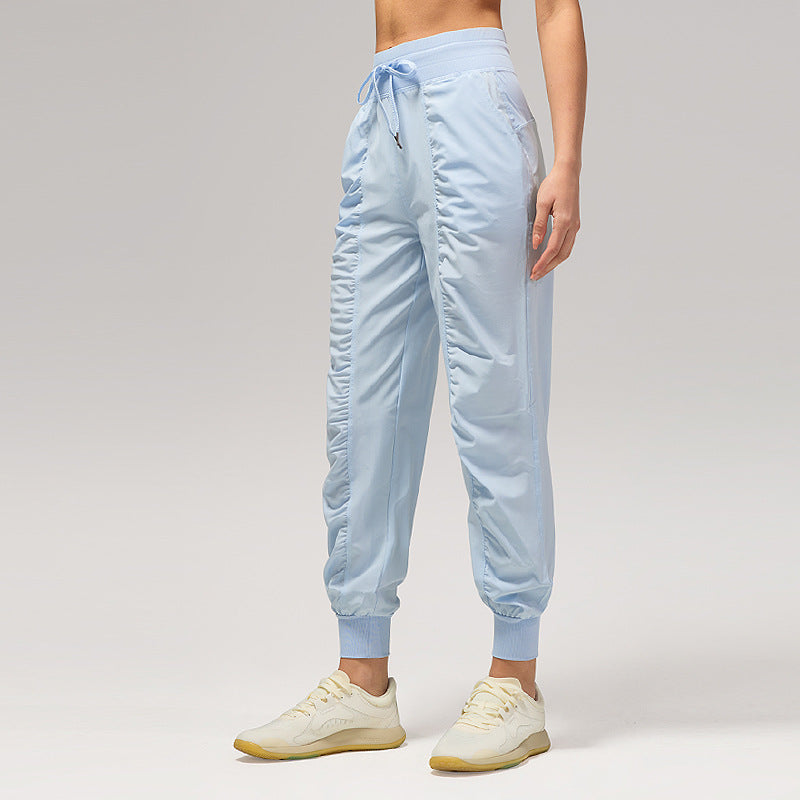 Women’s loose light blue jogger pants with drawstring waist and cuffed ankles, side pockets.