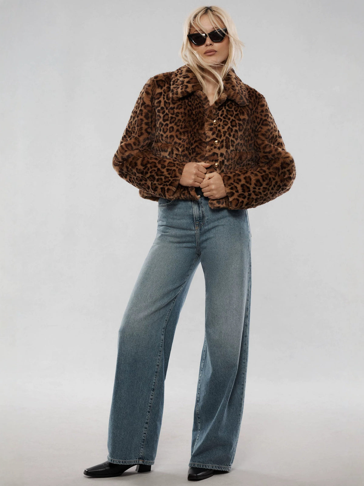 Leopard print faux fur short coat, model standing wearing blue jeans