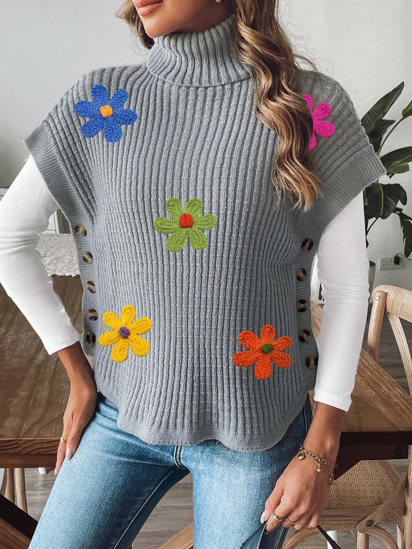 Light gray knit high-neck sweater vest with colorful flower appliques and button accents