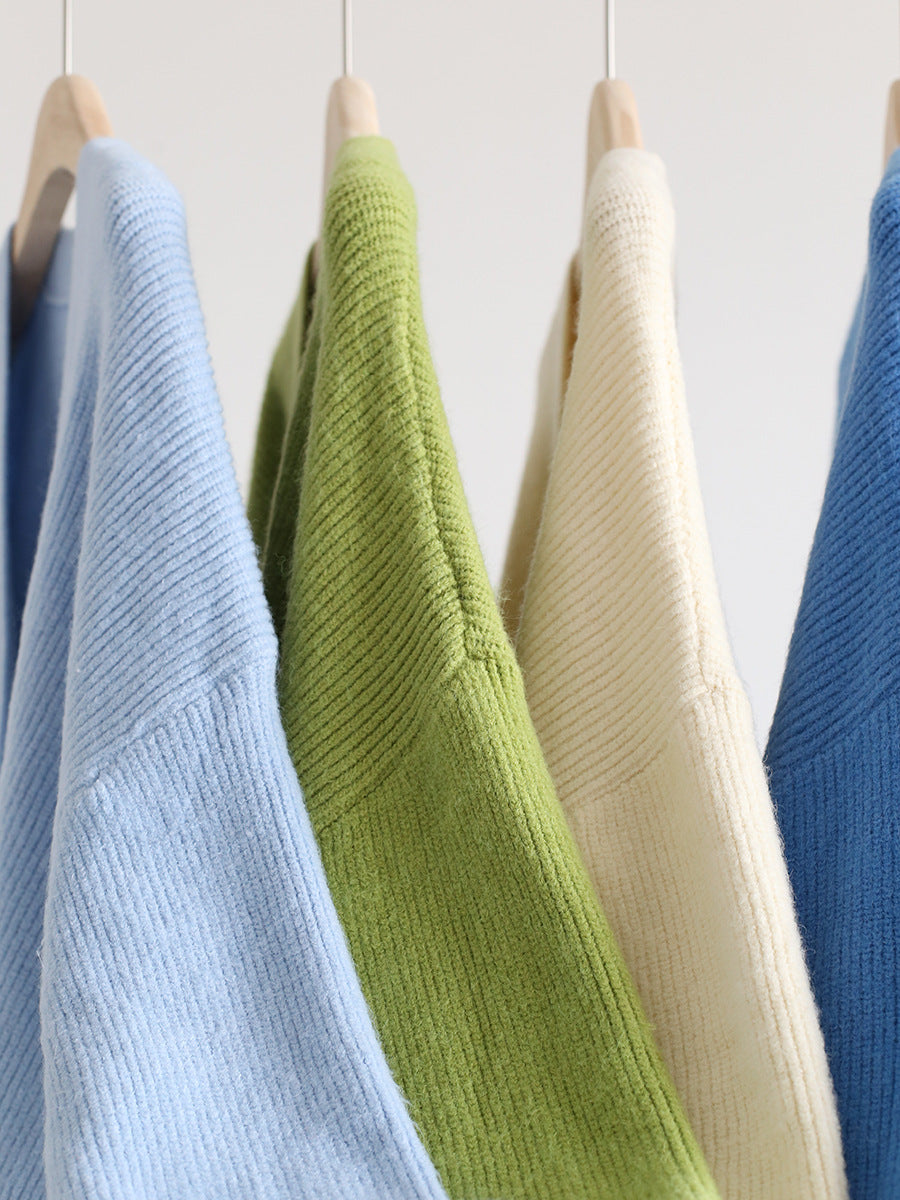 V-neck mohair cardigan in light blue, green, and cream on hangers