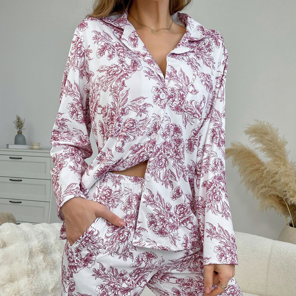 Women’s printed pajama set with V-lapel long-sleeve top and matching pajama trousers, hand detail