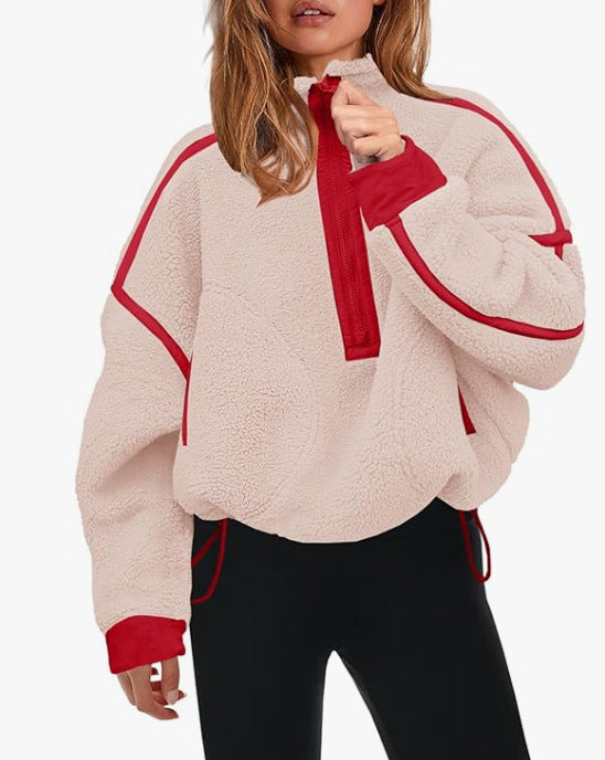 Plush quarter-zip sweatshirt in light pink with red trim and pull tab