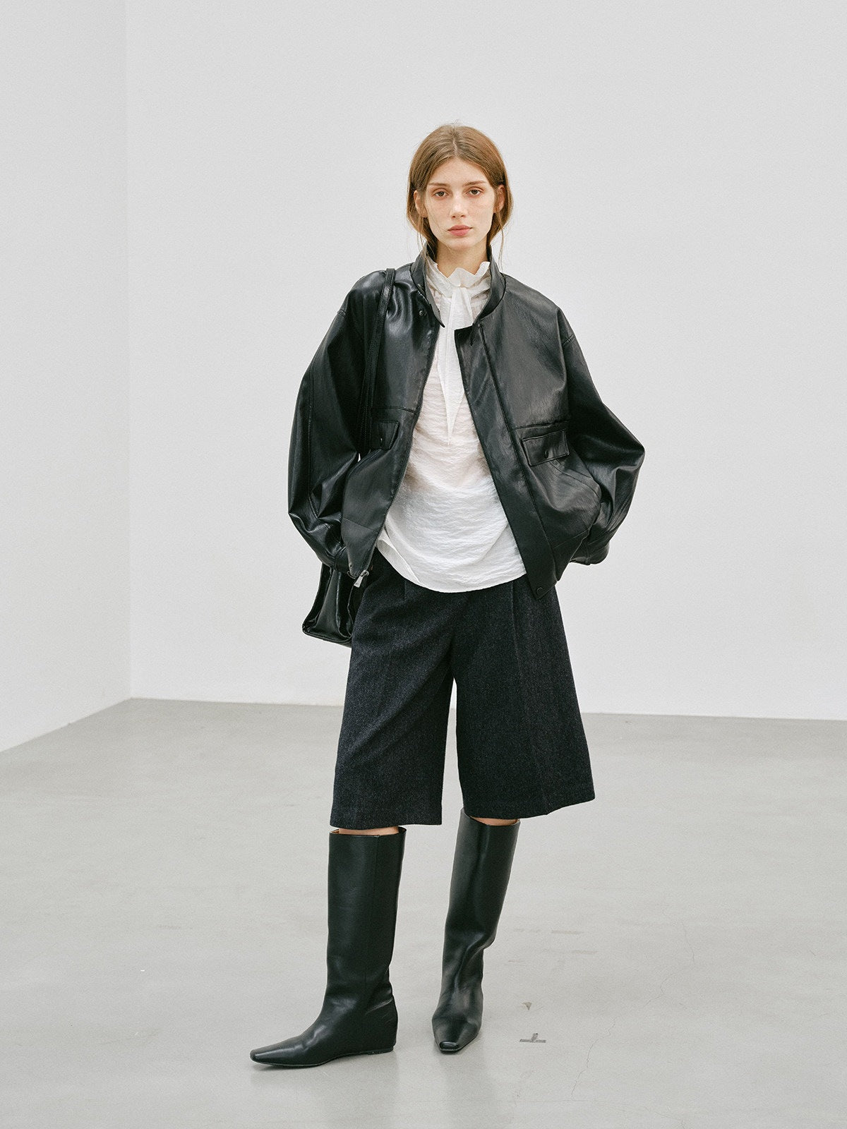 Black PU leather short jacket with stand-up collar and flap pockets, open front drape