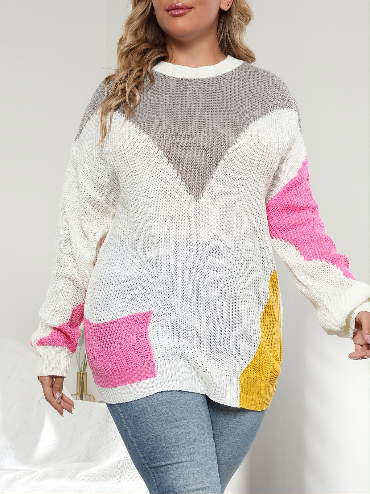 Relaxed plus size knit sweater in white with pink sleeve accents and yellow contrast panel