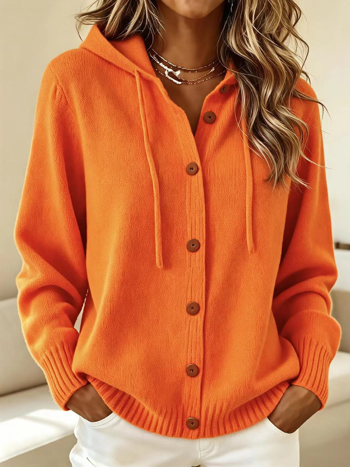 Orange hooded knit cardigan sweater with front button placket and drawstring hood