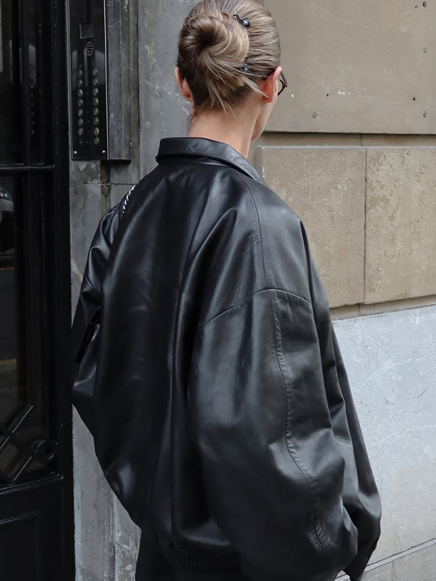 Back view of black matte leather jacket with long sleeves and shoulder yoke