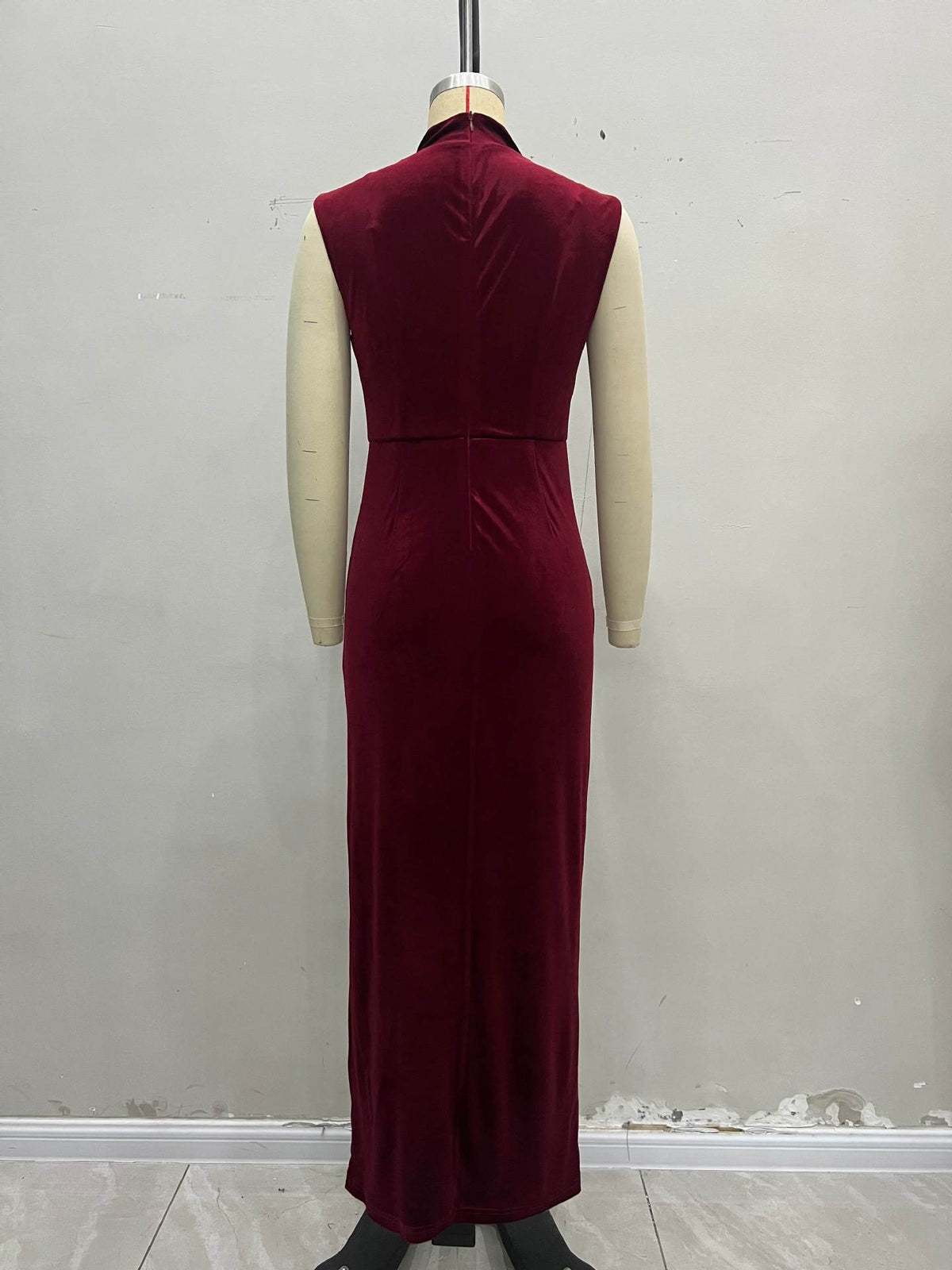 Burgundy velvet sleeveless long evening dress on mannequin, stand collar, fitted waist.