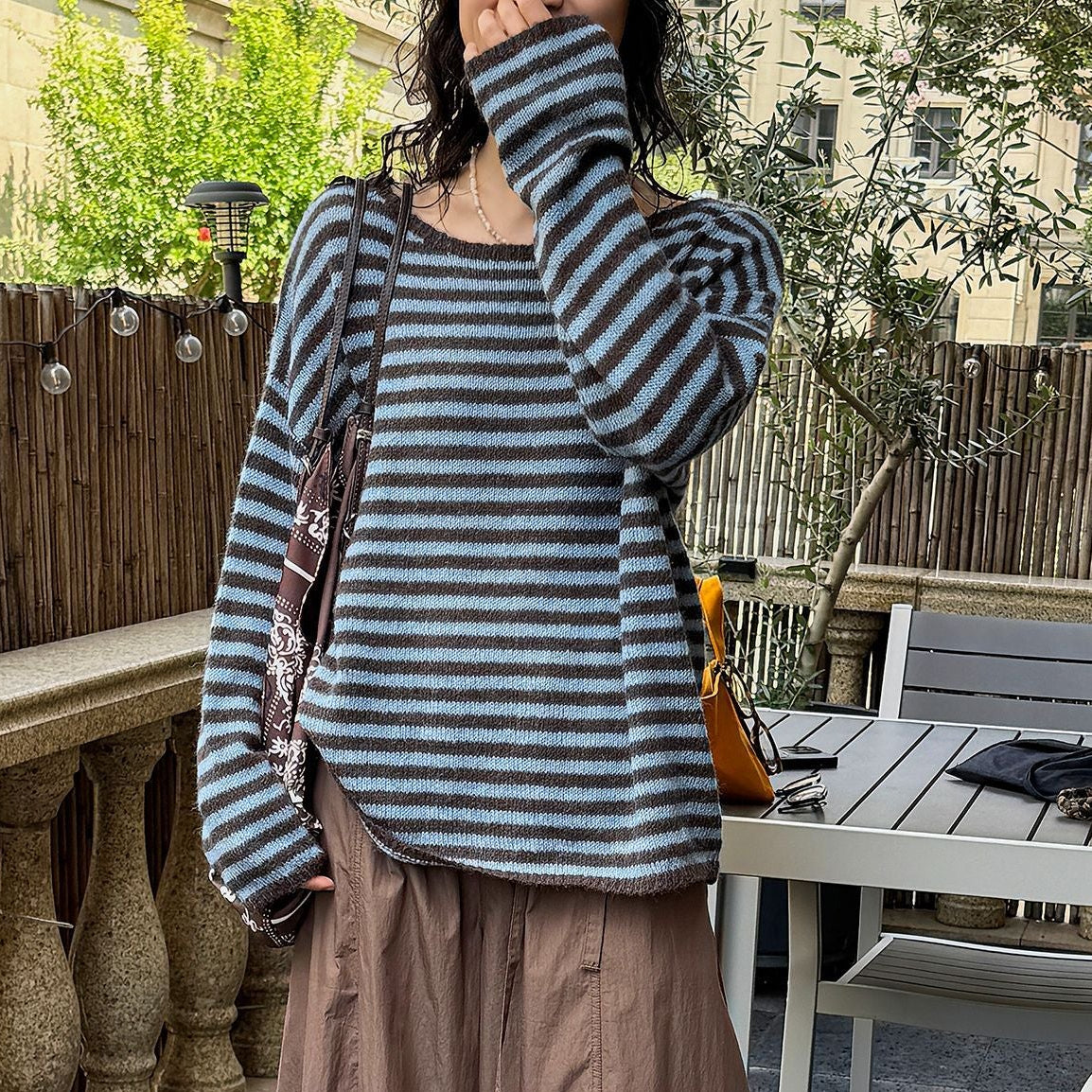 Blue-and-gray striped wool sweater with loose fit, long sleeves, round neckline.