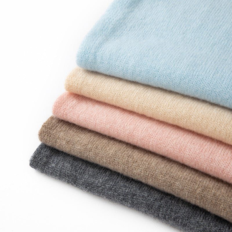Stack of cashmere triangle scarves in dark gray, beige, pink, and sky blue