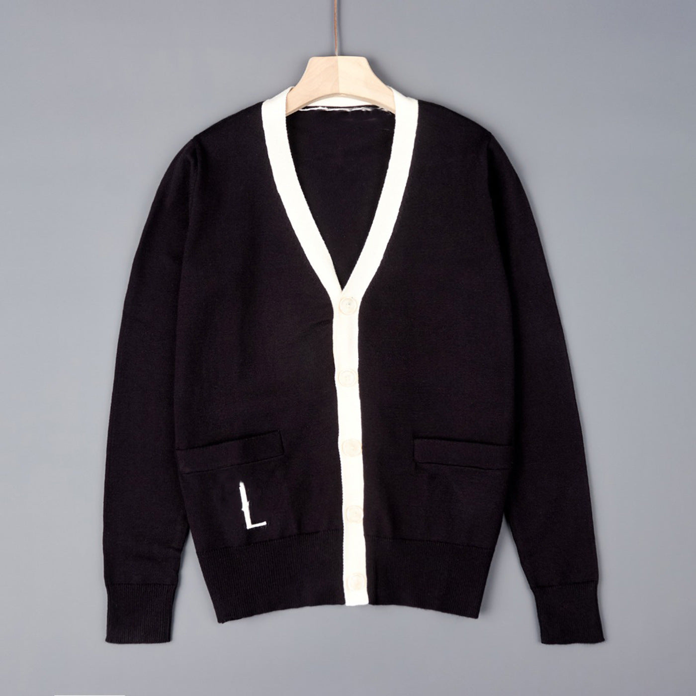 Black V-neck knit cardigan with off-white trim, button front, and chest pockets