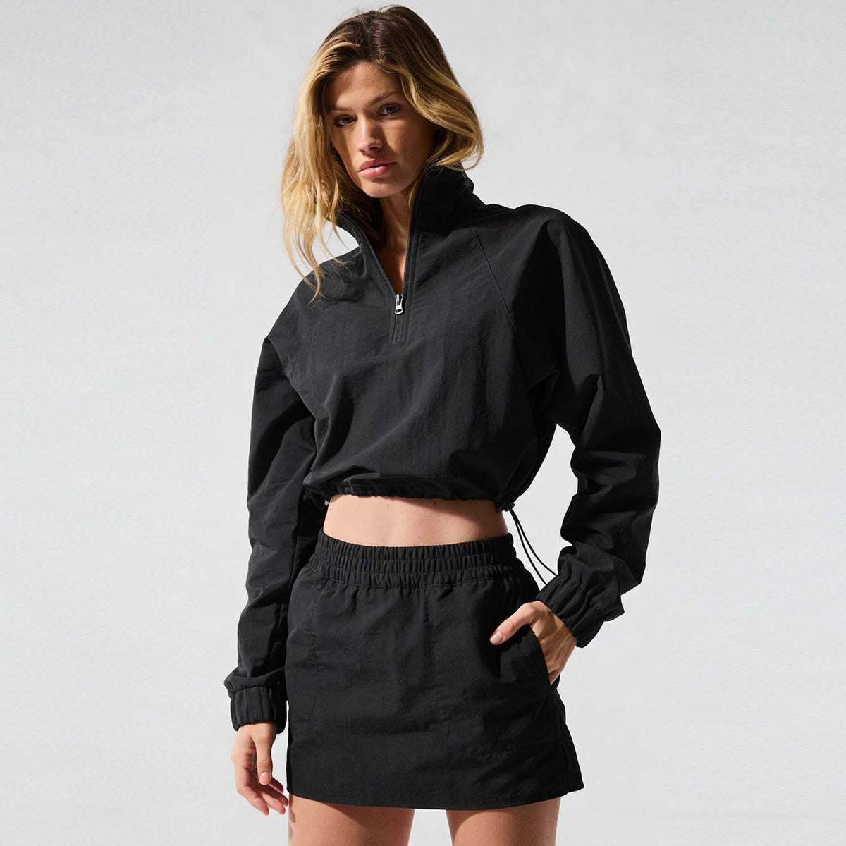 Women’s black quarter-zip jacket and mini skirt set with elastic waist