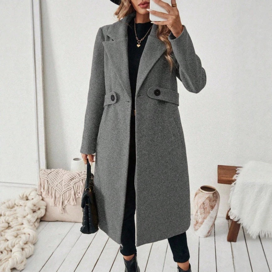 Gray wool long coat with notched lapels, double-breasted button front, and flap pockets.