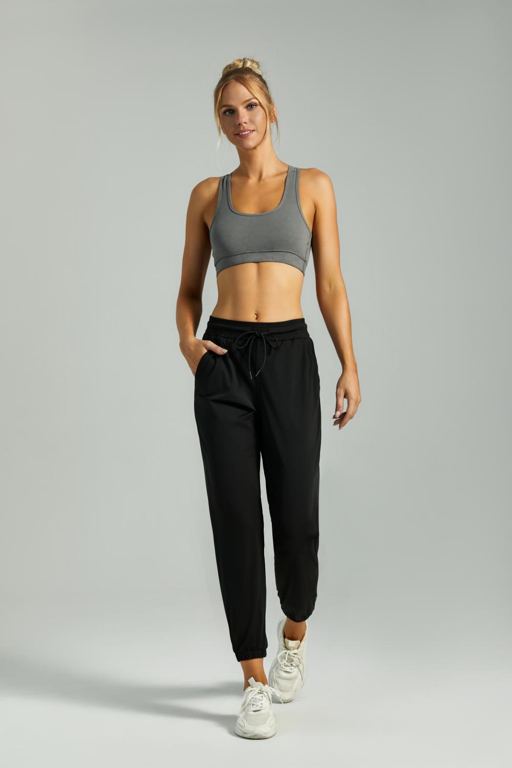Women's black jogger pants with drawstring waist, side pockets, and cuffed hems