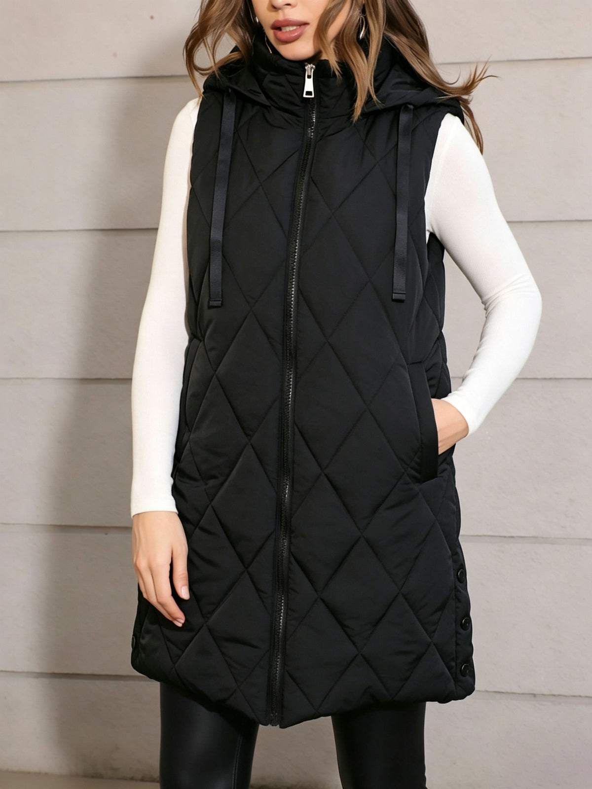 Black hooded quilted sleeveless vest with front zipper and two side pockets