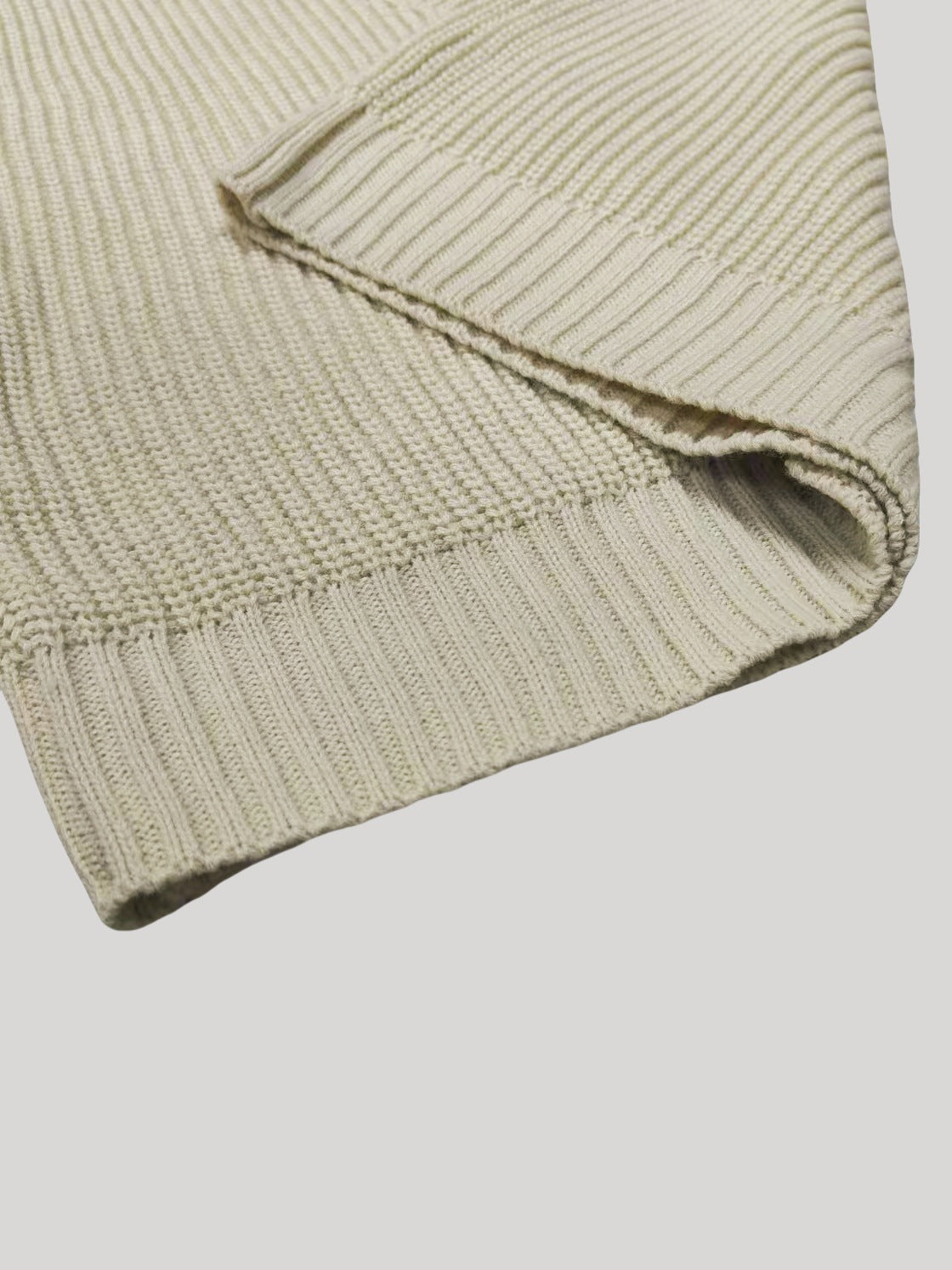 Off-white cardigan hem close-up with ribbed knit trim