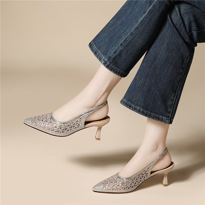 Silver pointed-toe slingback heels with geometric cutout upper and block heel on feet.
