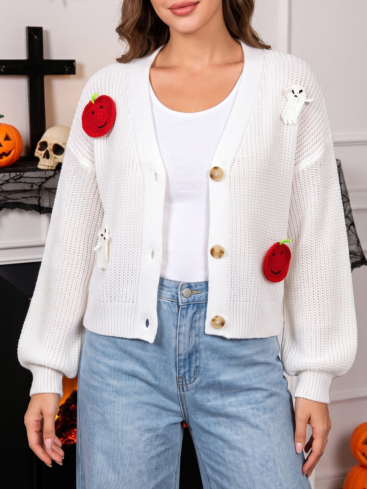 White knitted cardigan with long sleeves, button front, red pumpkins and ghost motifs