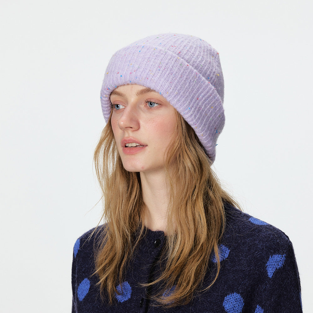 Light purple speckled rib-knit beanie with a wide folded cuff, modeled.